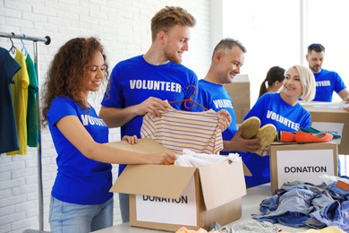 Team of volunteers collecting donations in boxes indoors