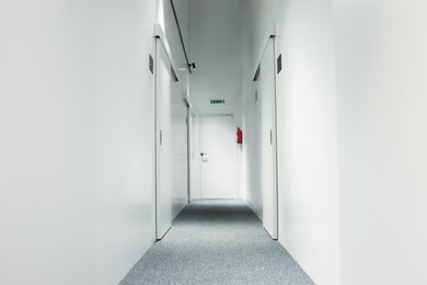 Narrow white hallway in hostel. Modern design