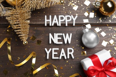 Flat lay composition with phrase Happy New Year and festive decor on wooden background