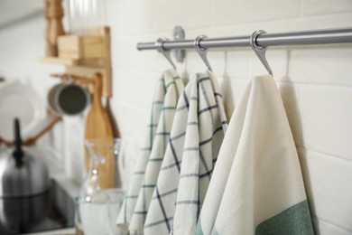 Different clean towels hanging on rack in kitchen