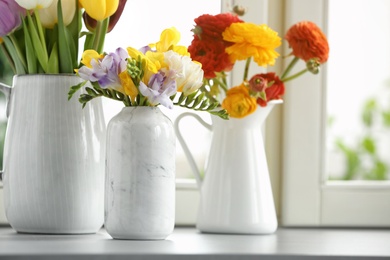 Photo of Different beautiful spring flowers on window sill