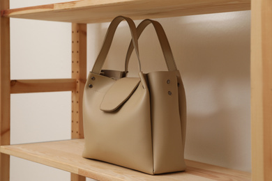 Stylish woman's bag on shelf in boutique