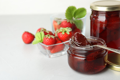 Delicious pickled strawberry jam and fresh berries on light table. Space for text