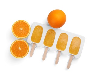 Tasty orange ice pops in mold isolated on white, top view. Fruit popsicle