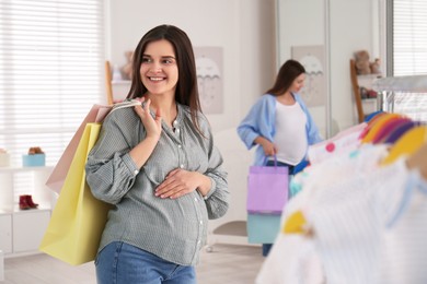 Happy pregnant woman with shopping bags in store