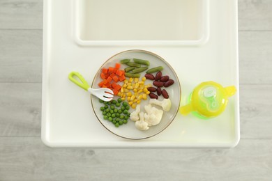 Baby high chair with healthy food and water, top view
