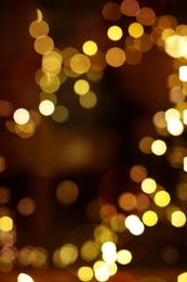 Blurred view of glowing lights on color background. Winter holiday