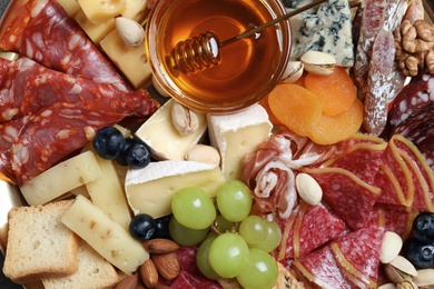 Different appetizers with delicious honey as background, top view