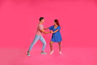 Beautiful lovely couple dancing on pink background