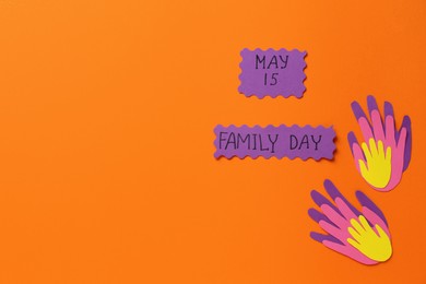 Paper palms and cards with words Family Day on orange background, flat lay. Space for text