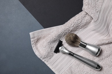 Razor, brush and towel for shaving on dark background, flat lay