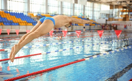 Young athletic man jumping in swimming pool