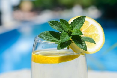 Photo of Refreshing water with lemon and mint on blurred background, closeup