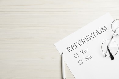 Referendum ballot with pen and glasses on white wooden table, flat lay. Space for text