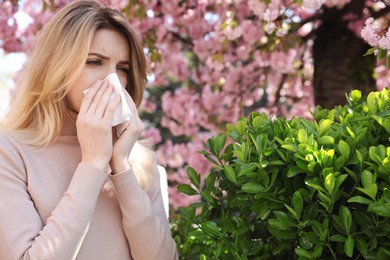Woman suffering from seasonal pollen allergy outdoors