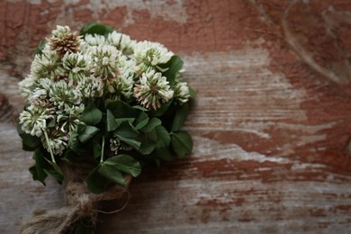 Photo of Bunch of beautiful clover plant on wooden table, top view. Space for text