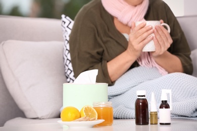 Different cough remedies and ill woman on background