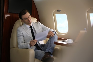 Businessman working with documents in airplane during flight