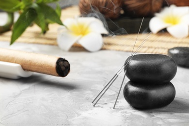 Needles for acupuncture and stones on table