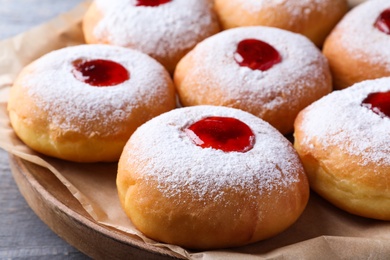 Hanukkah doughnuts with jelly and sugar powder on grey table, closeup