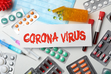 Flat lay composition with phrase CORONA VIRUS and medicines on white background