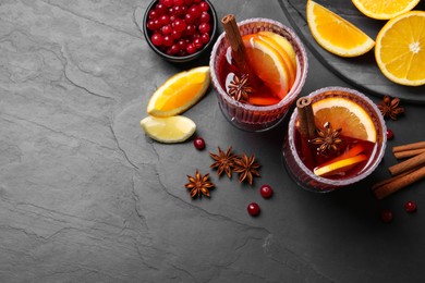 Aromatic punch drink and ingredients on black table, flat lay. Space for text