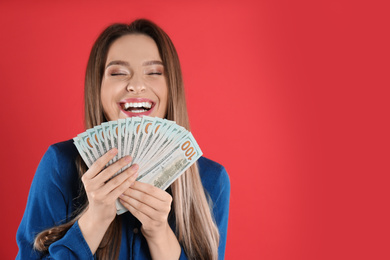 Young woman with money on crimson background. Space for text