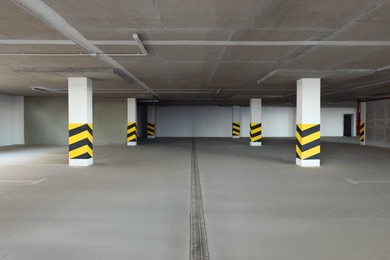 Empty car parking garage with warning stripes on columns