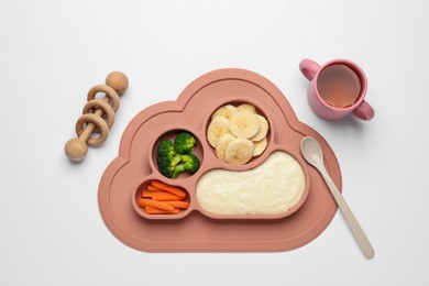 Healthy baby food in plate, cup with drink and toy on white background, top view