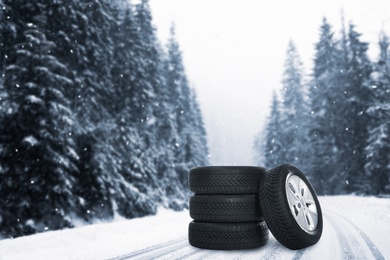 Set of wheels with winter tires outdoors on snowy road 