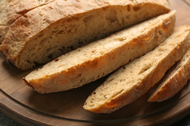 Tasty freshly baked bread on wooden board, closeup