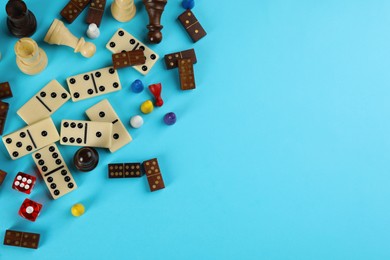 Components of board games on light blue background, flat lay. Space for text