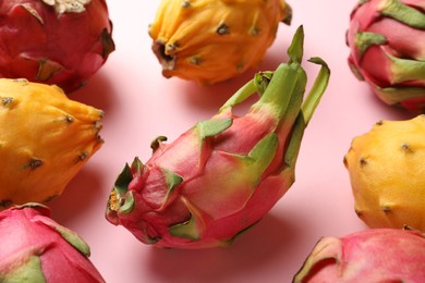 Different pitahaya fruits on light pink background, closeup