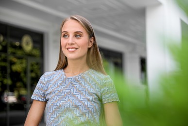Photo of Beautiful young woman in stylish t-shirt near building outdoors