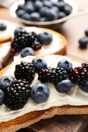 Tasty sandwiches with cream cheese and berries, closeup