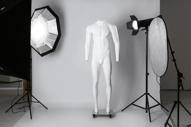 Ghost mannequin and professional lighting equipment in modern photo studio