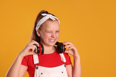 Cute indie girl with headphones on yellow background, space for text