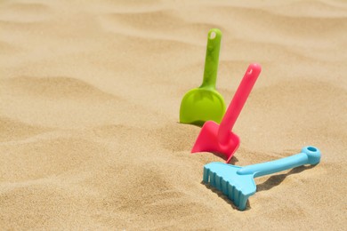 Set of colorful beach toys on sand, space for text