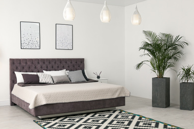 Elegant interior of modern comfortable bedroom with green plants