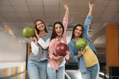 Group of young women with balls in bowling club