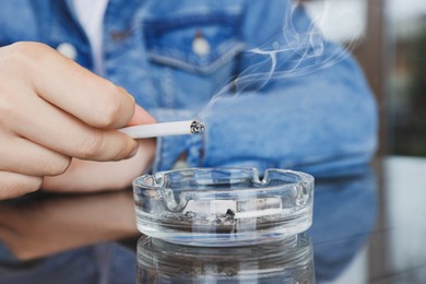 Man smoking cigarette at table in outdoor cafe, closeup