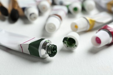 Tubes with paints on blank canvas, closeup