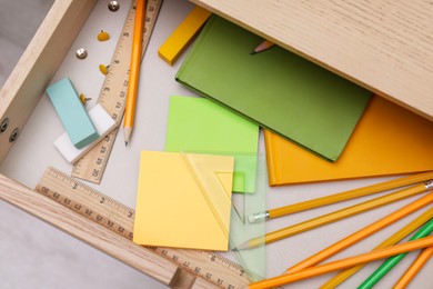 Photo of Office supplies in open desk drawer, top view