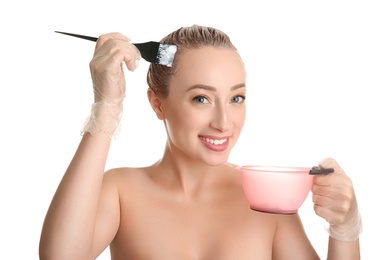 Young woman dyeing her hair against white background