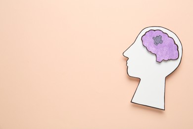 Top view of human head cutout with brain on beige background, space for text. Epilepsy awareness