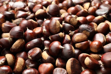 Fresh edible sweet chestnuts as background, closeup