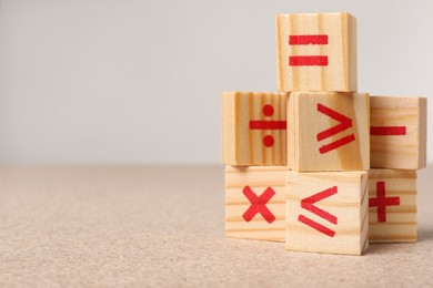 Photo of Wooden cubes with mathematical symbols on table against light background. Space for text