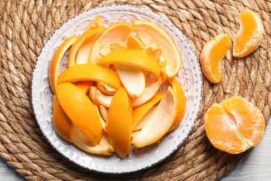 Photo of Orange peels preparing for drying and fresh fruit on white wooden table, top view