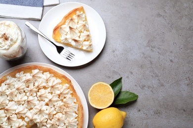 Cut delicious lemon meringue pie served on grey table, flat lay. Space for text