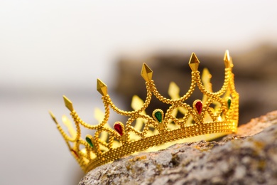 Beautiful golden crown on stone outdoors, closeup. Fantasy item